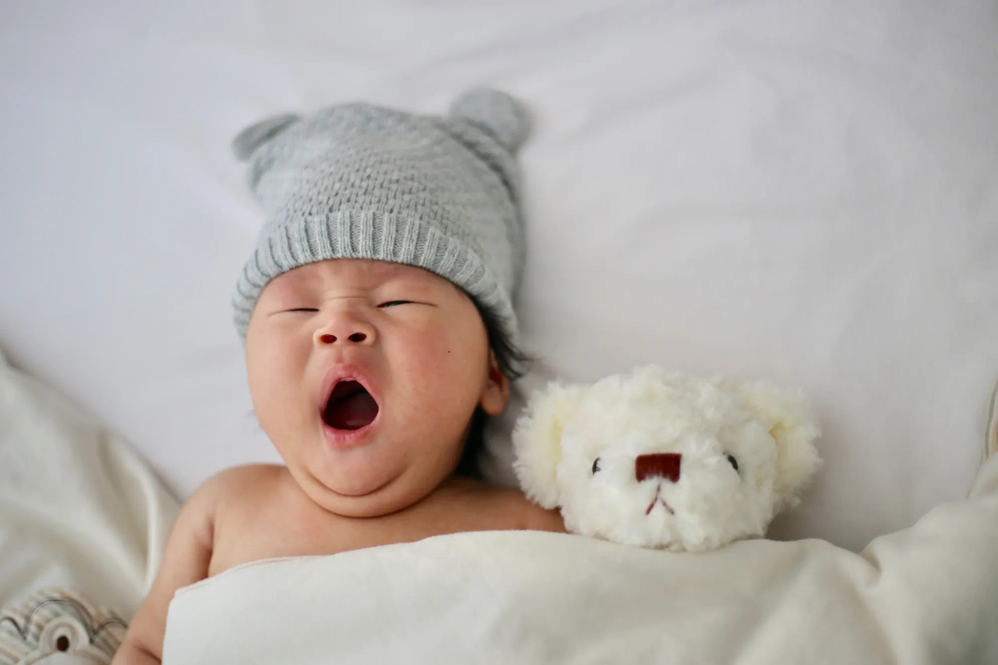 yawning baby, baby with teddy