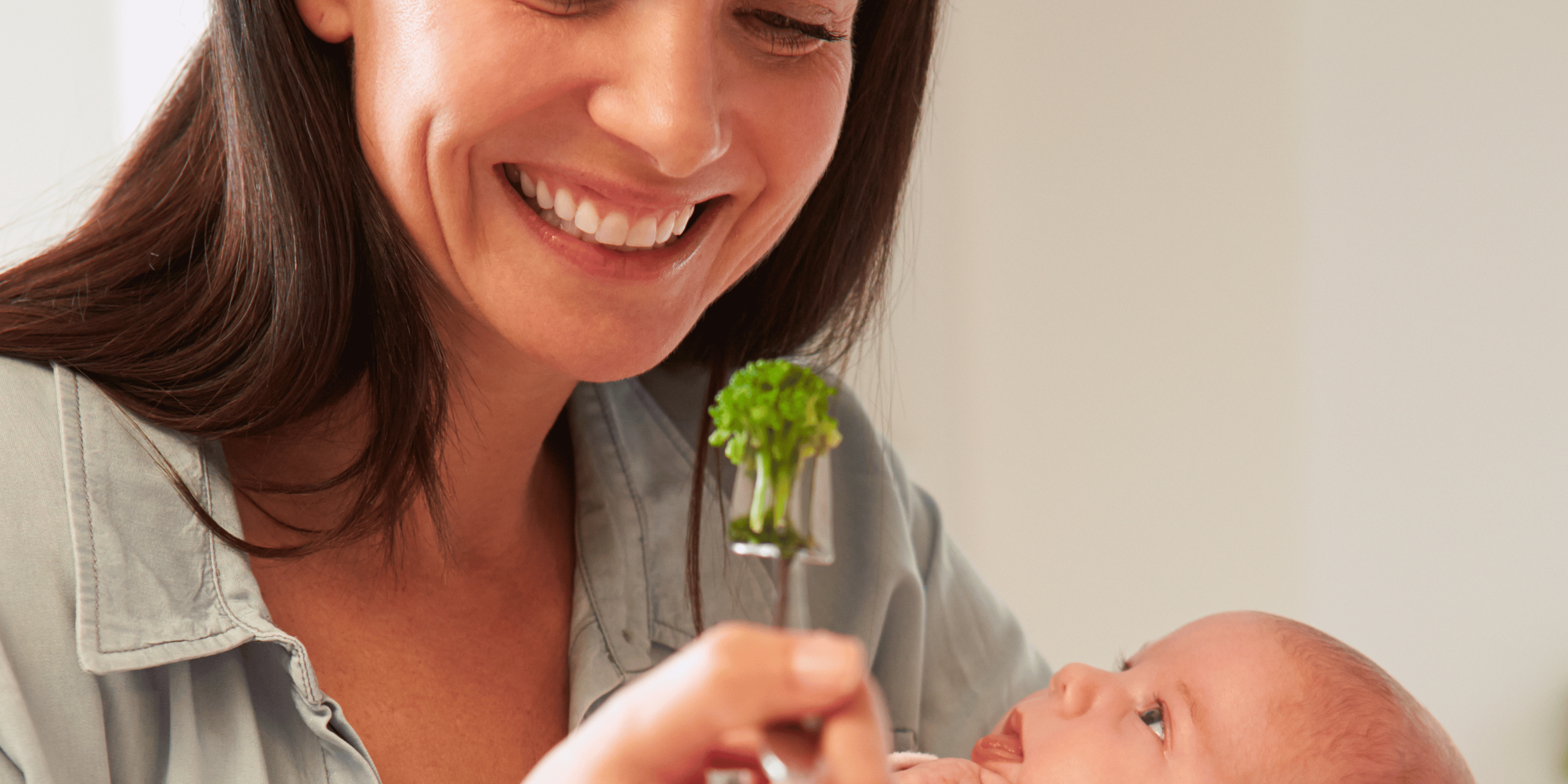 mom eating with baby, holding baby while eating