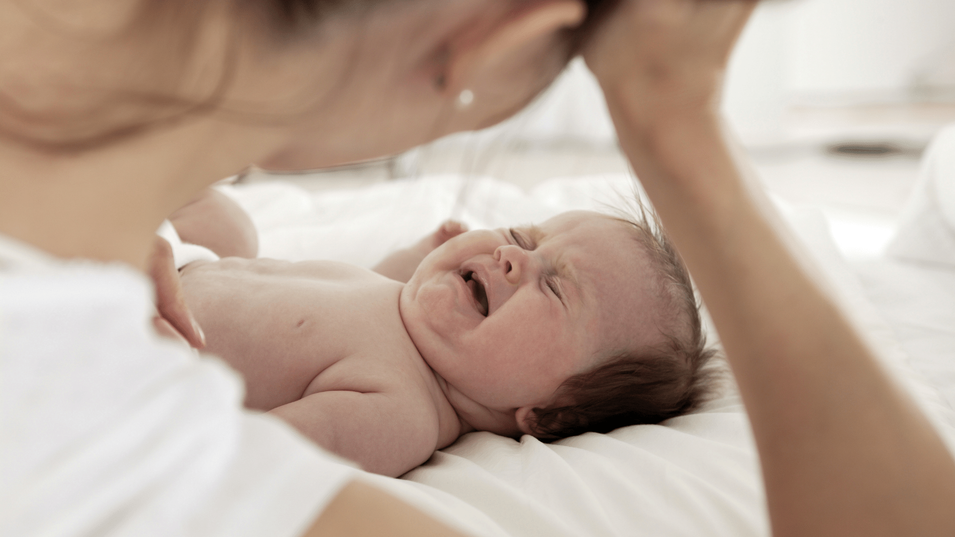 infant cries during nursing, baby crying during breastfeeding, newborn fussiness while nursing, baby fussing during feeding