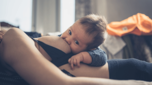 bigger baby breastfeeding and looking at the camera