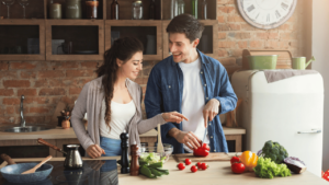 two people in a kitchen making food