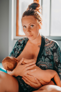 Mother holding her baby skin-to-skin and breastfeeding.