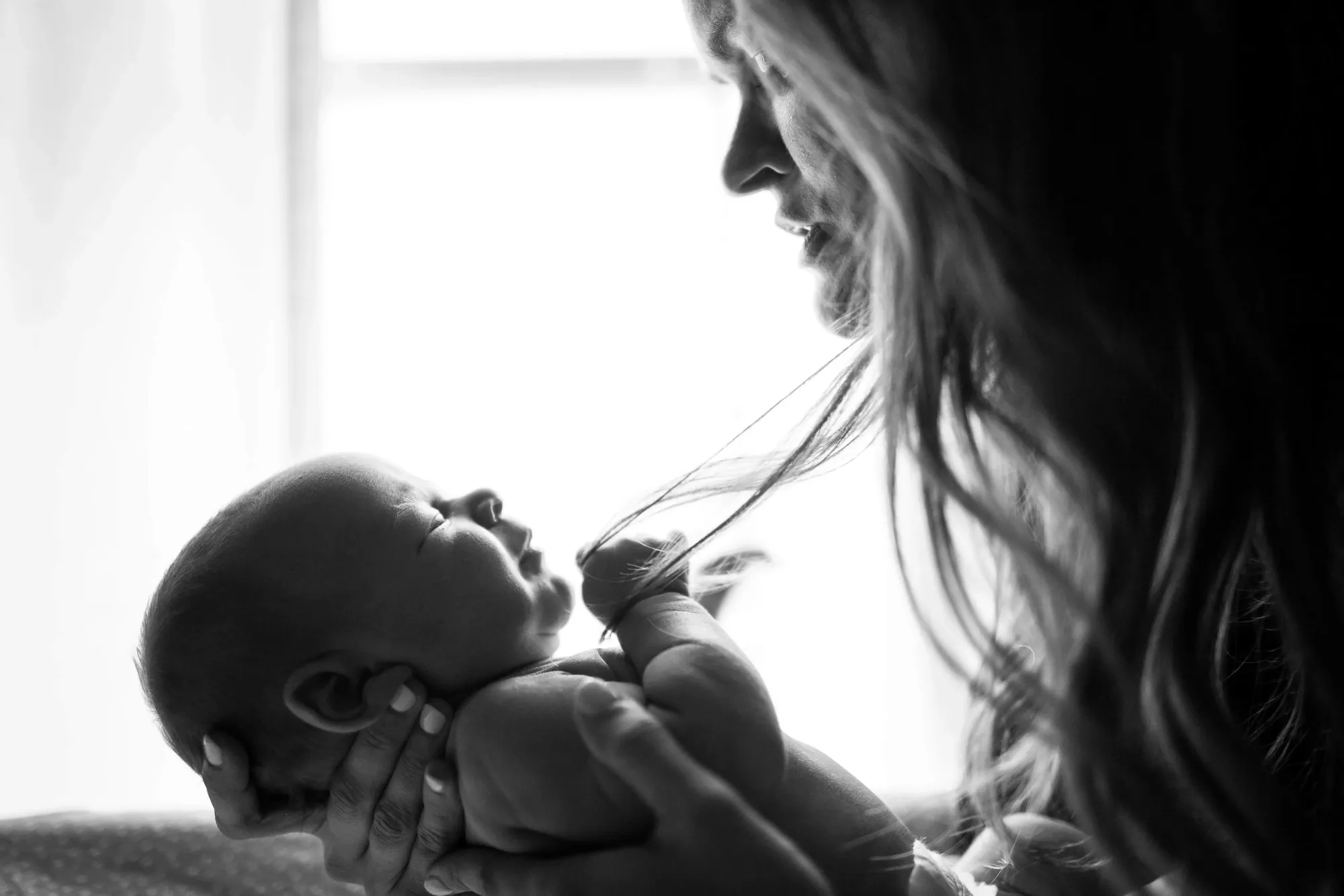 How to breastfeed with tubular hypoplastic breasts. Mother holding her baby.